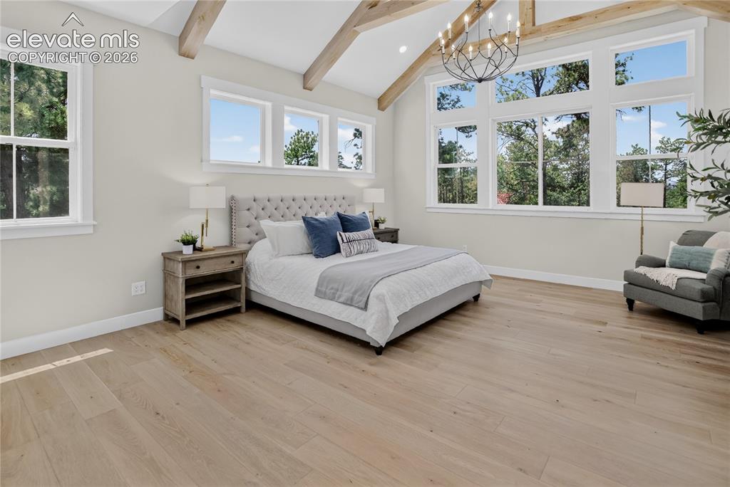 Image 21 of 47: Primary suite w/ exposed beam vaulted ceiling