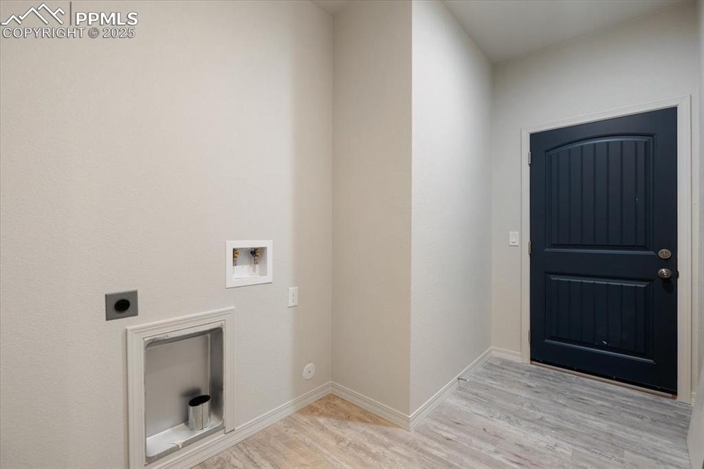 Image 17 of 22: Laundry area featuring light wood-type flooring, washer hookup, and electri