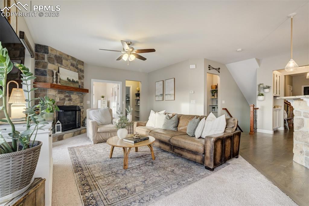 Image 14 of 50: Fireplace with stone surround in the living room. 