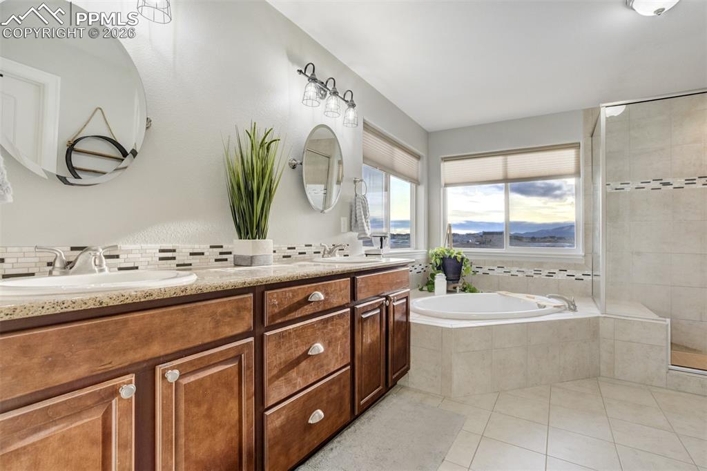 Image 25 of 50: Primary bathroom with dual sinks, soaking tub, shower & large walk-in close