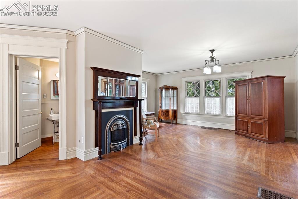 Image 14 of 50: Living room with a fireplace and ornamental molding