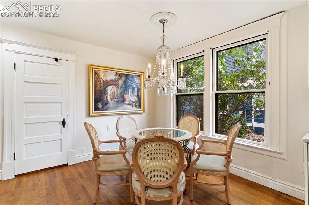 Image 24 of 50: Dining room featuring a chandelier and wood finished floors
