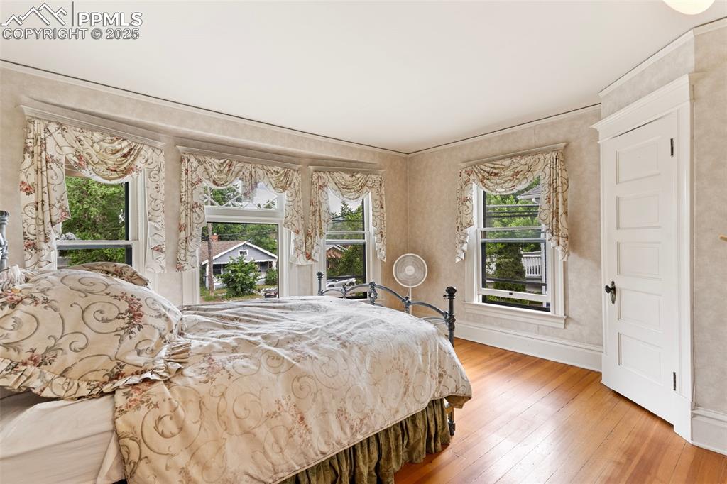 Image 26 of 50: Bedroom featuring multiple windows and hardwood / wood-style floors