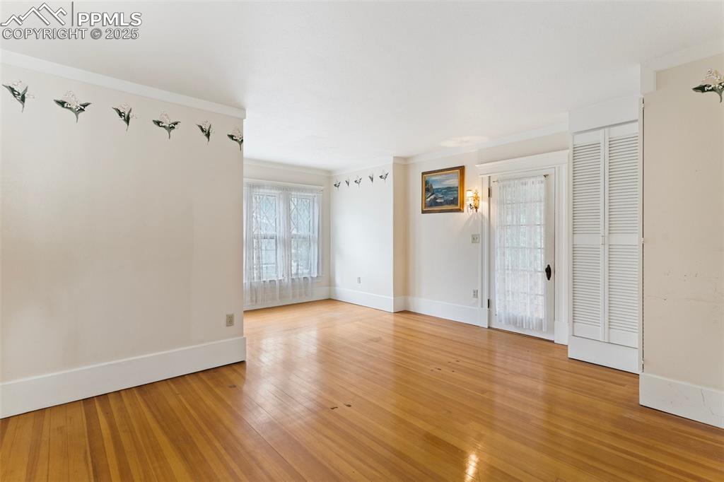 Image 28 of 50: Unfurnished room featuring light wood-type flooring and ornamental molding