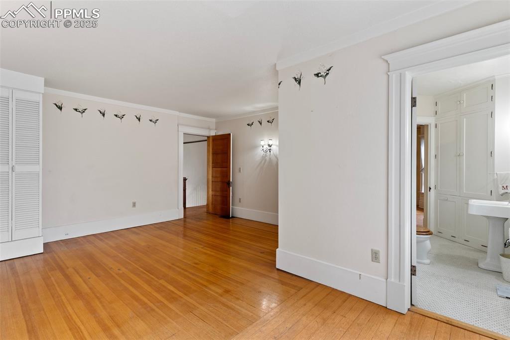 Image 29 of 50: Empty room featuring light wood-style flooring and ornamental molding