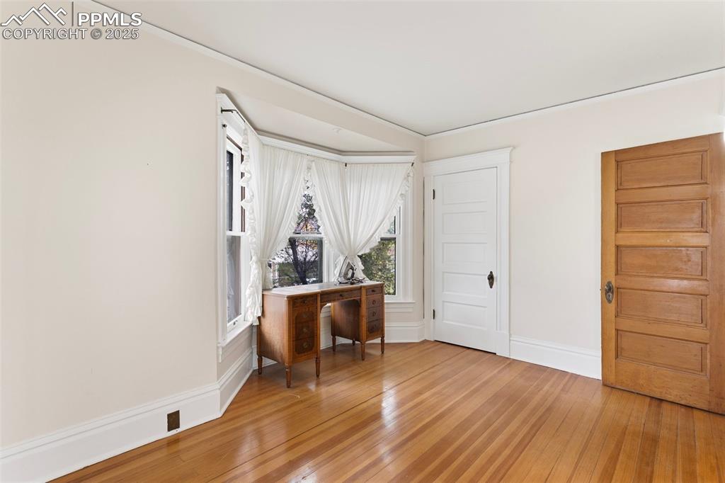 Image 35 of 50: Office space with light wood-style flooring and ornamental molding