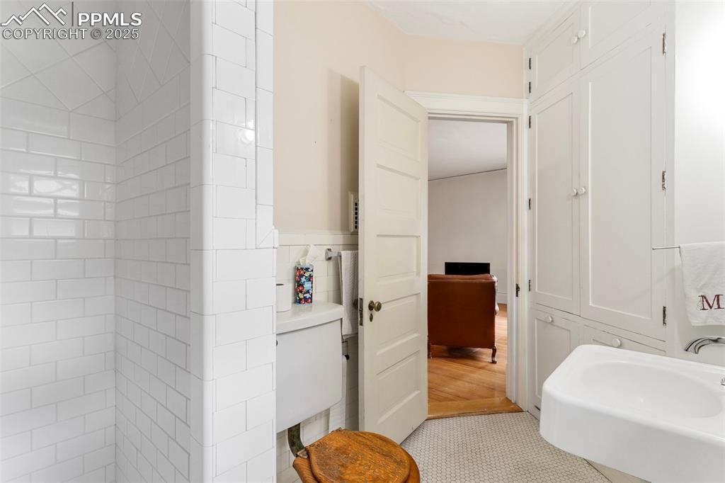Image 40 of 50: Bathroom featuring wainscoting and tile patterned flooring