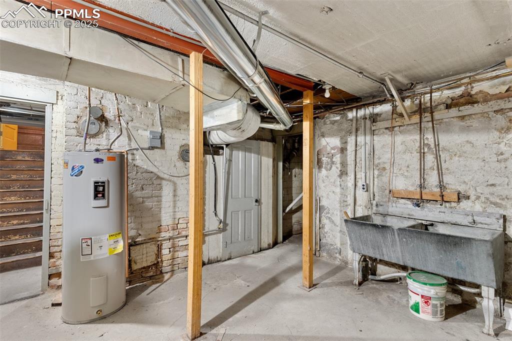 Image 47 of 50: Unfinished basement featuring water heater