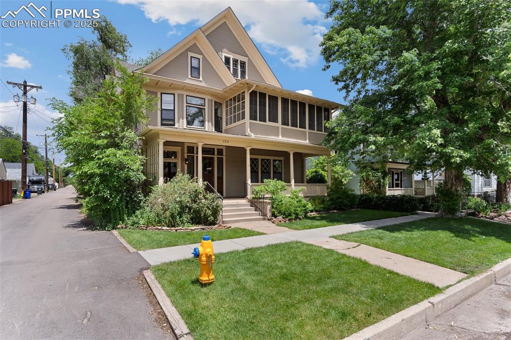 Image 6 of 50: View of front facade featuring a front yard, a sunroom, and covered porch