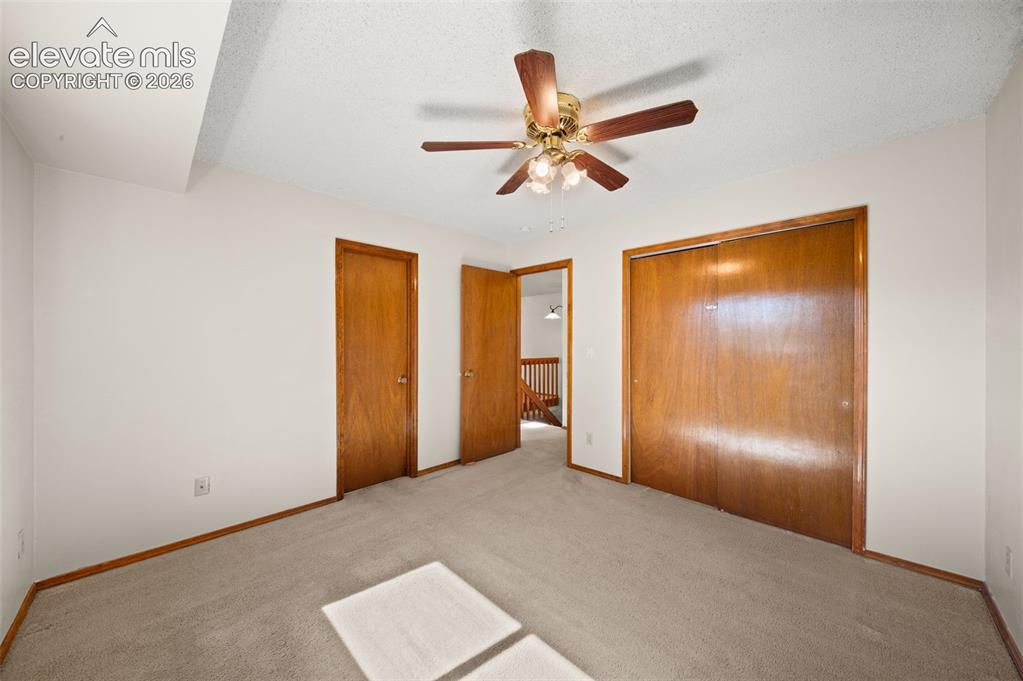 Image 19 of 40: Carpeted room featuring a ceiling fan with integrated lighting, wood-finish