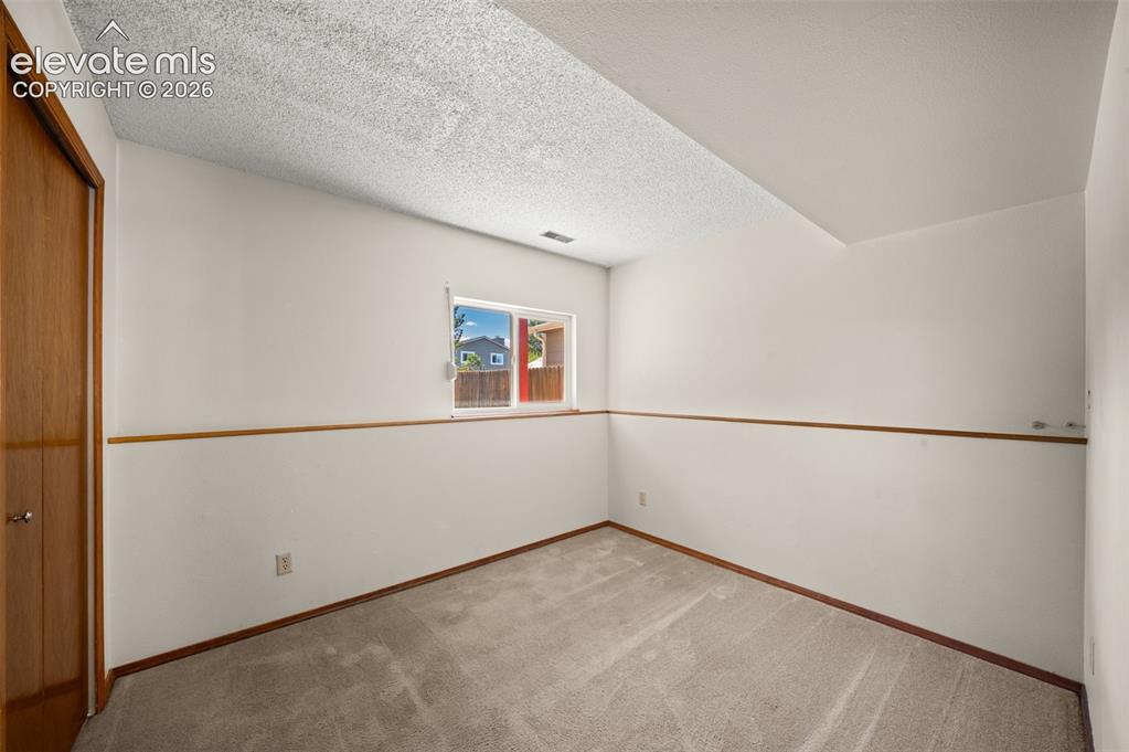 Image 26 of 40: Carpeted flooring, wood-finish trim, window with wood-finish sill, neutral 