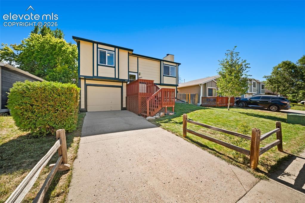 Image 4 of 40: Two-story exterior with a contrasting trim, attached garage, concrete drive