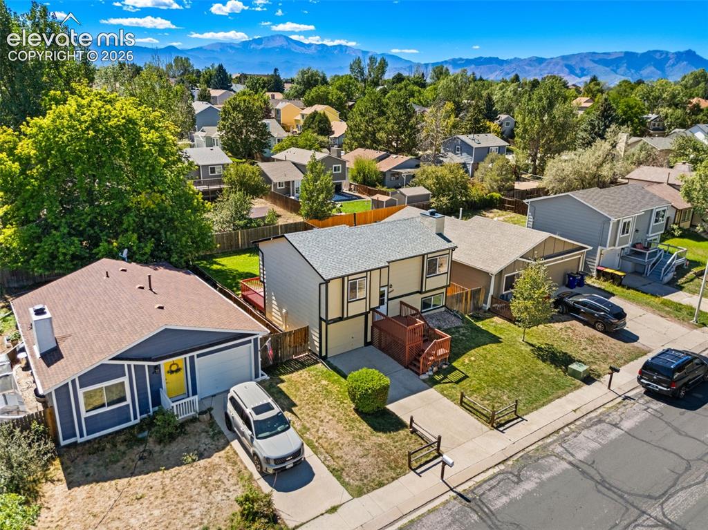 Image 40 of 40: Neighborhood setting with mountain scenery, mature trees, and residential a