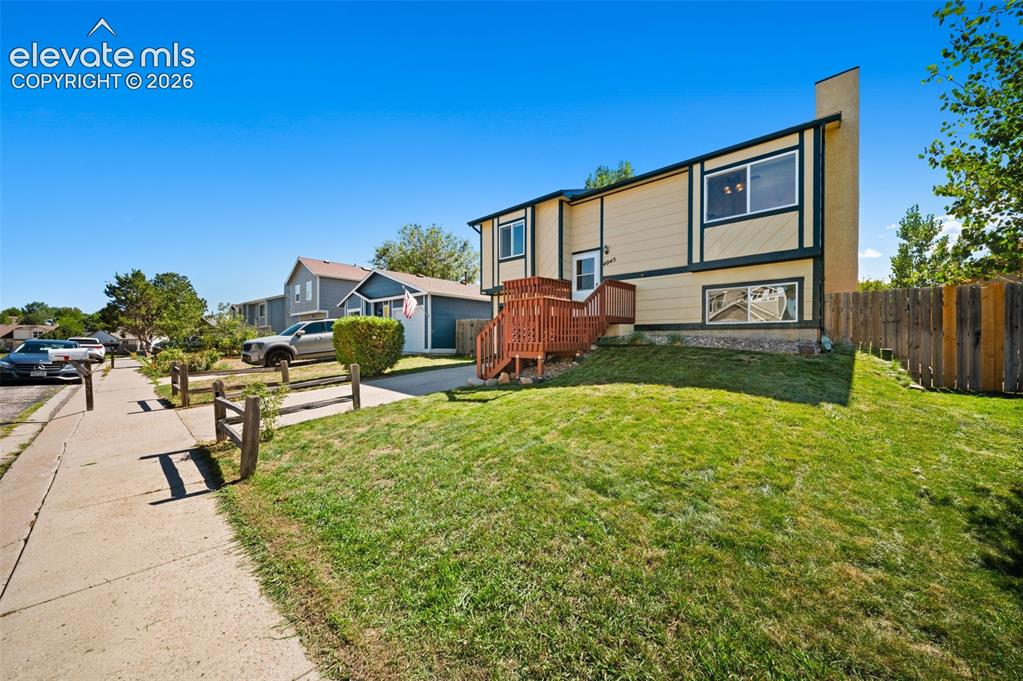 Image 5 of 40: Split-level exterior with siding, a wood deck, and a fenced backyard
