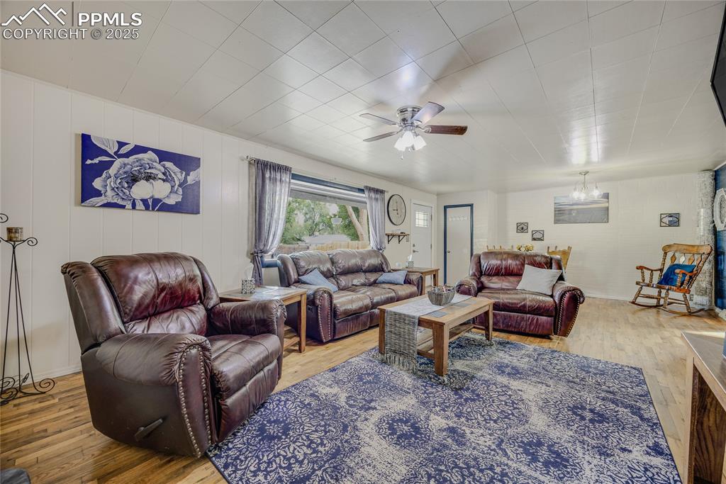 Image 10 of 31: Living room featuring wood finished floors and a ceiling fan