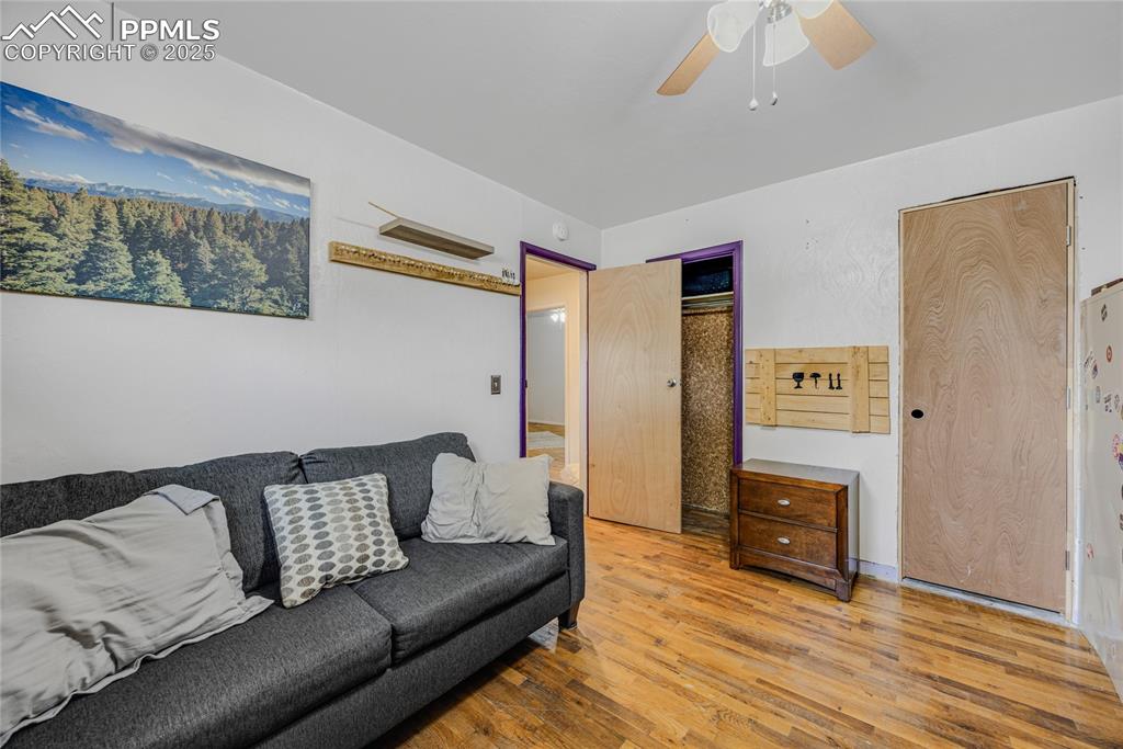 Image 20 of 31: Living room with wood finished floors and ceiling fan