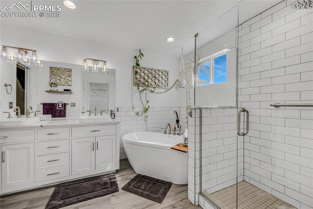 Image 25 of 31: Full bath featuring tile walls, a soaking tub, a stall shower, recessed lig