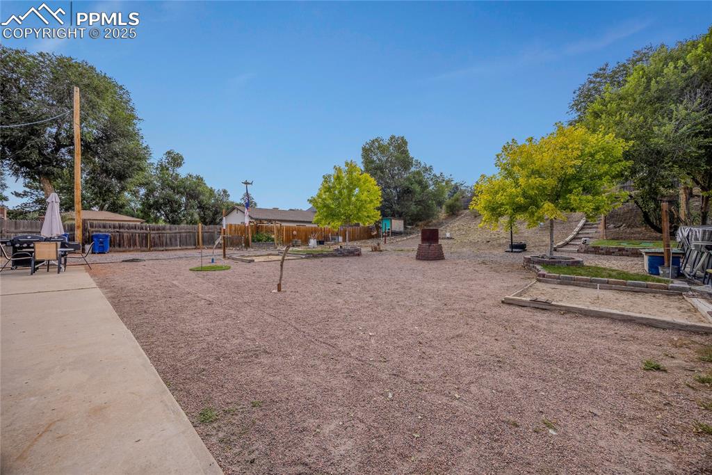 Image 27 of 31: View of playground featuring a fenced backyard