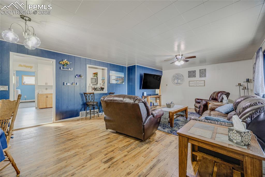 Image 7 of 31: Living area featuring hardwood / wood-style floors, ceiling fan, and wood w