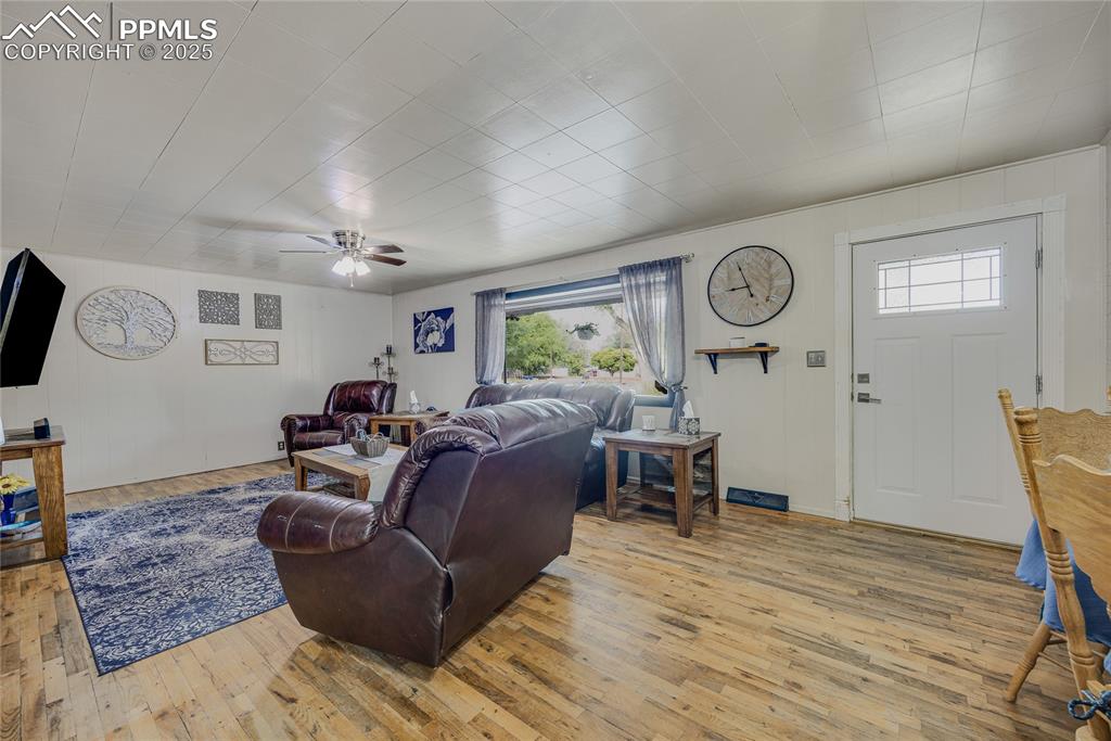 Image 9 of 31: Living room with light wood finished floors and ceiling fan