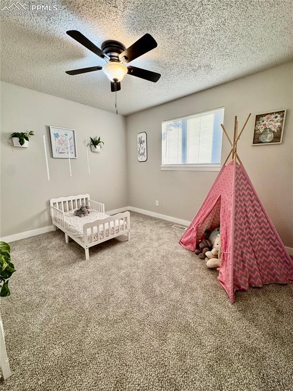 Image 10 of 27: Carpeted room featuring a ceiling fan with integrated lighting, a window wi