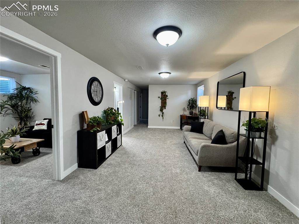 Image 15 of 27: Spacious room featuring light gray carpet flooring, white baseboards, and n