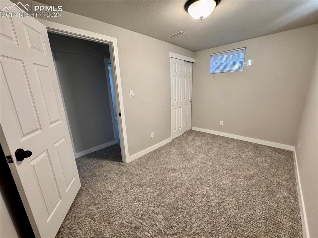 Image 19 of 27: Interior room featuring neutral wall paint, textured carpeting, and white t
