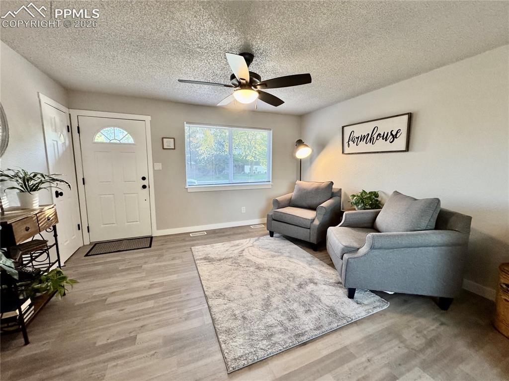 Image 4 of 27: Inviting living area featuring light gray walls, wood-finish flooring, a co