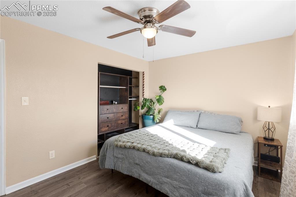 Image 21 of 32: Bedroom with dark wood-style flooring and ceiling fan