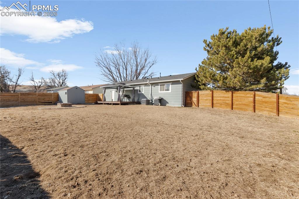 Image 31 of 32: Rear view of property with a storage unit and a fenced backyard