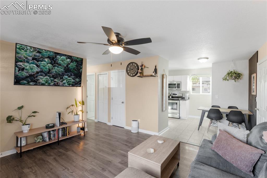 Image 6 of 32: Living room featuring light wood finished floors and a ceiling fan