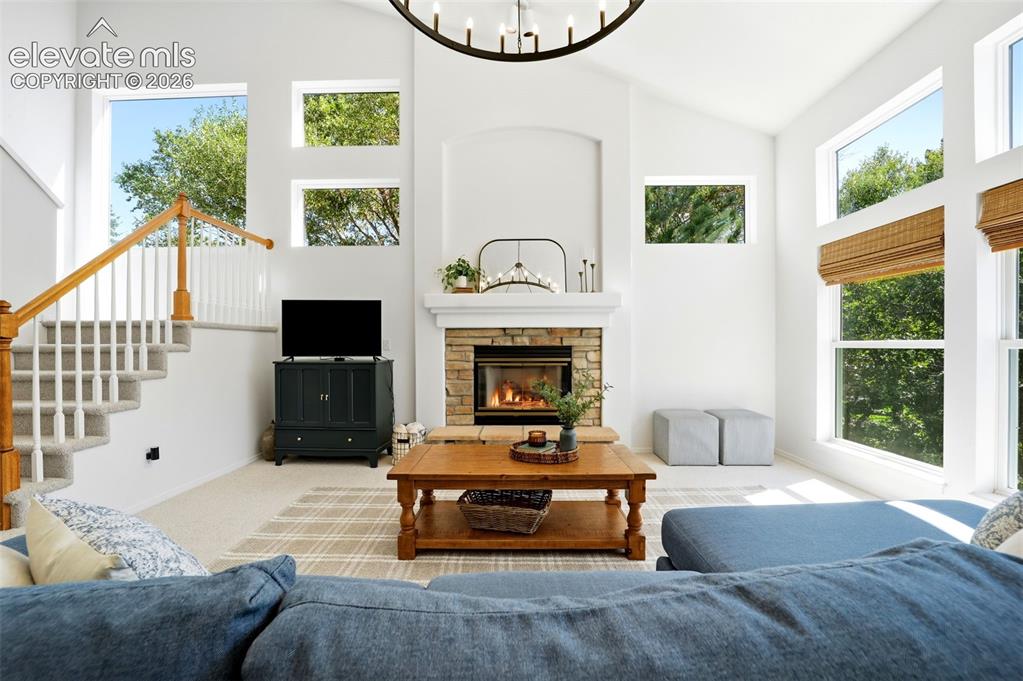 Image 10 of 50: Vaulted ceilings, tons of light, a stone fireplace, and a built-in staircas