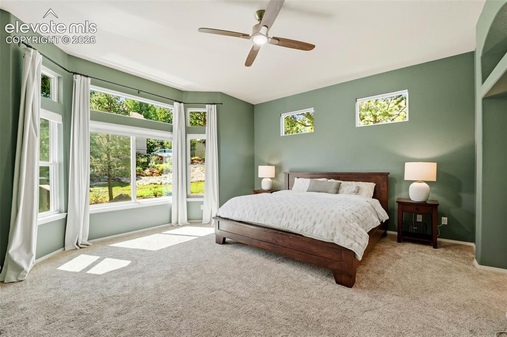 Image 17 of 50: Expansive bay windows with upper transom windows overlooking the backyard