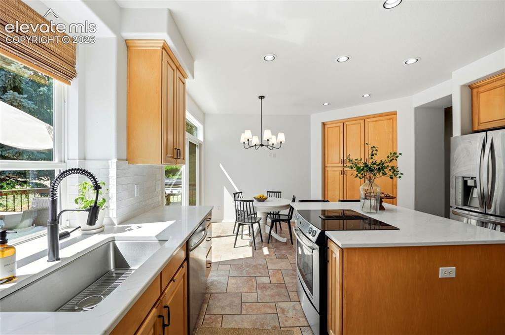 Image 20 of 50: Eat in kitchen the opens to the deck - perfect for entertaining!