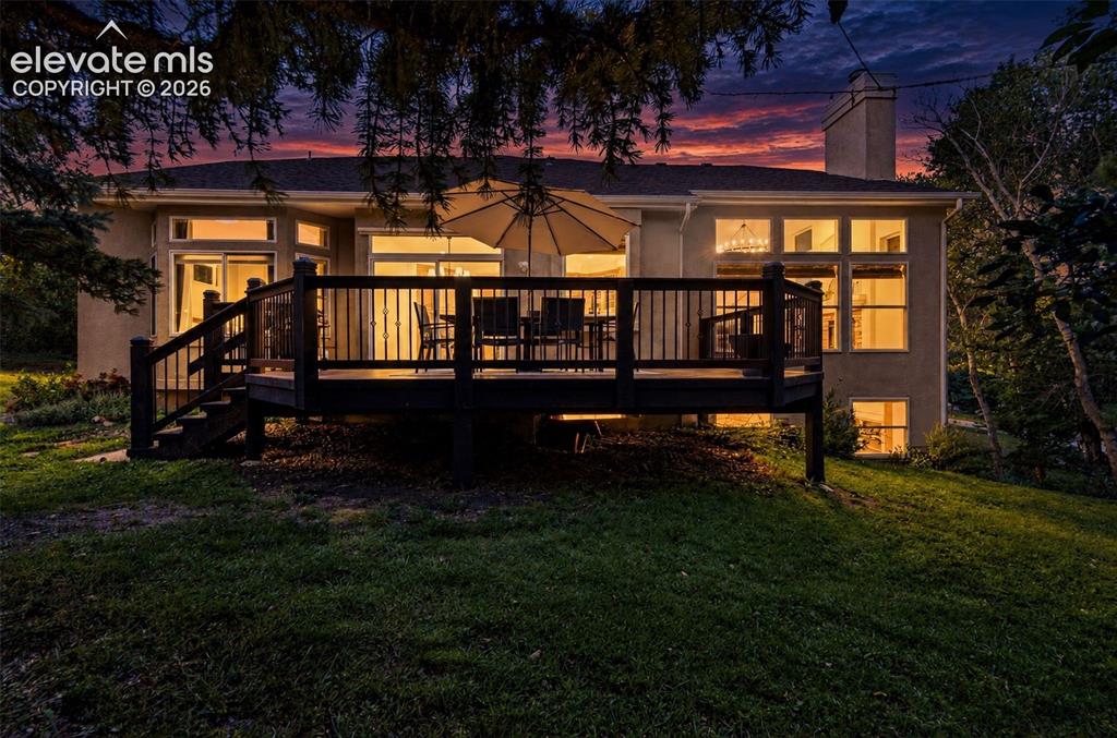 Image 39 of 50: Expansive rear deck with dark wood-finish railing, ground-level access, mul
