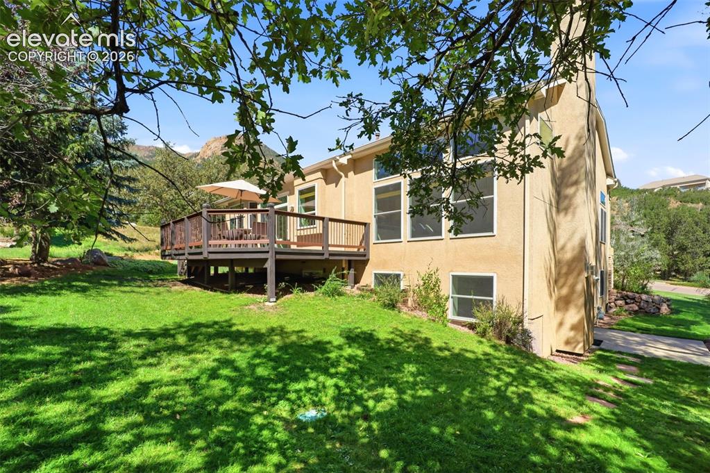 Image 40 of 50: Expansive rear deck, stucco exterior, multiple large windows, and a generou