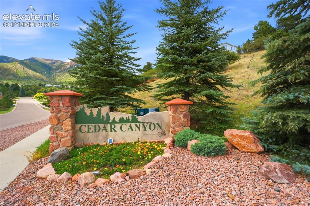 Image 42 of 50: Stone-clad monument sign for Cedar Canyon featuring integrated landscaping,
