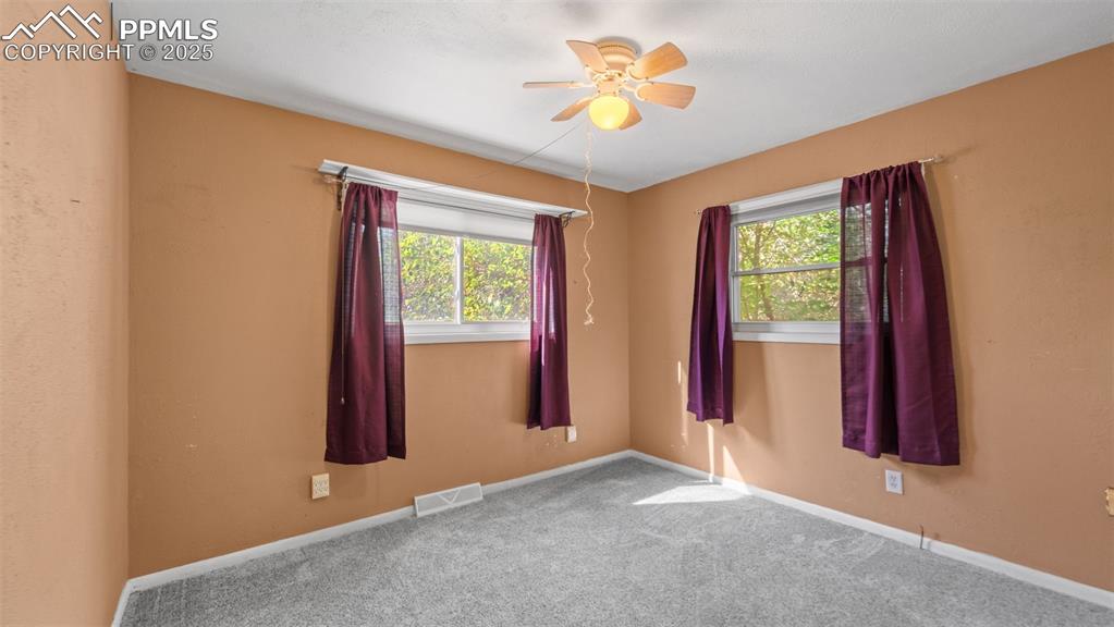 Image 11 of 33: Empty room featuring carpet floors and a ceiling fan