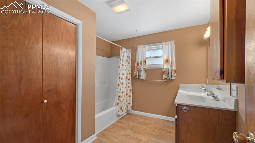 Image 12 of 33: Full bath featuring shower / bath combo, double vanity, and light wood fini