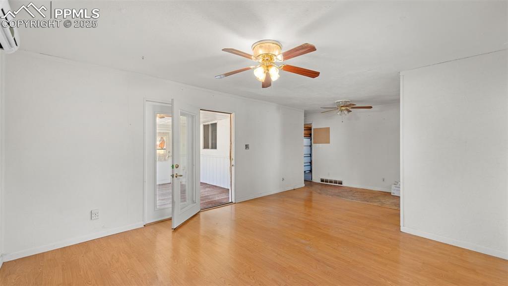 Image 18 of 33: Spare room featuring light wood-style flooring, an AC wall unit, and a ceil
