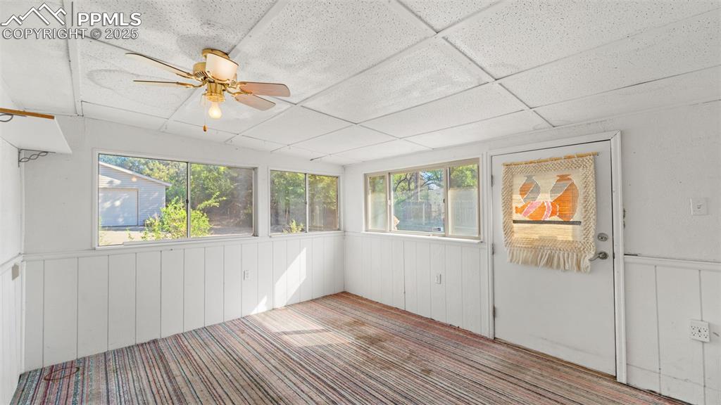 Image 19 of 33: Unfurnished sunroom with a drop ceiling and a wainscoted wall