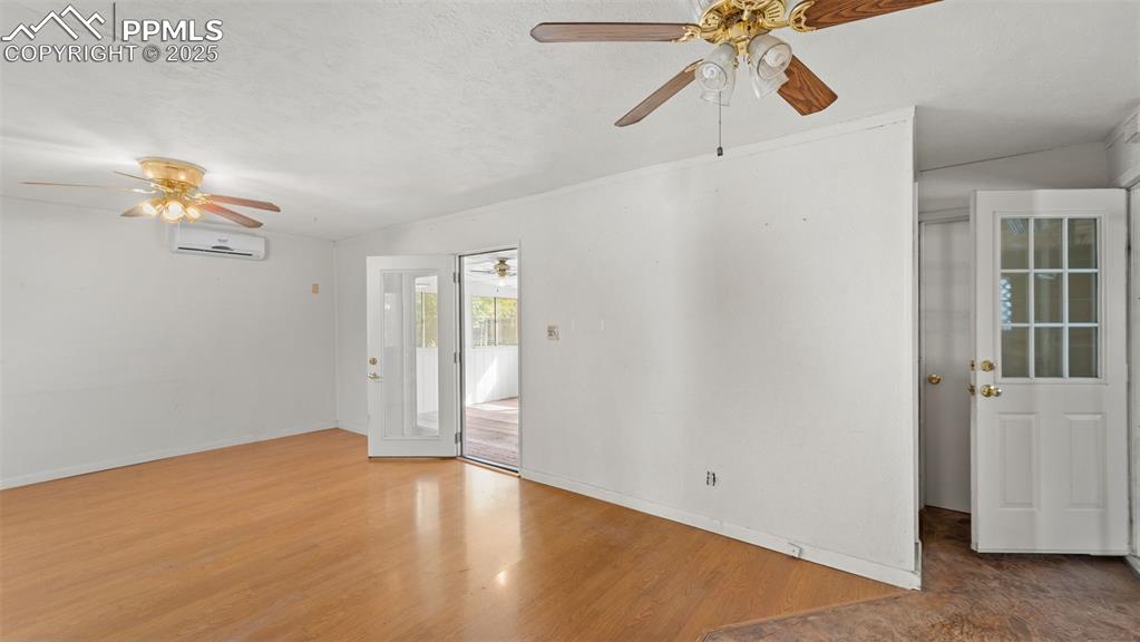 Image 21 of 33: Spare room featuring light wood-style floors, a textured ceiling, and an AC