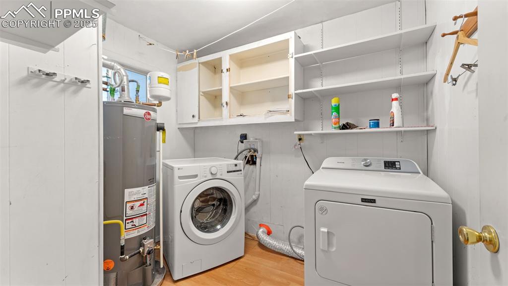 Image 22 of 33: Washroom featuring light wood-style floors, water heater, and separate wash