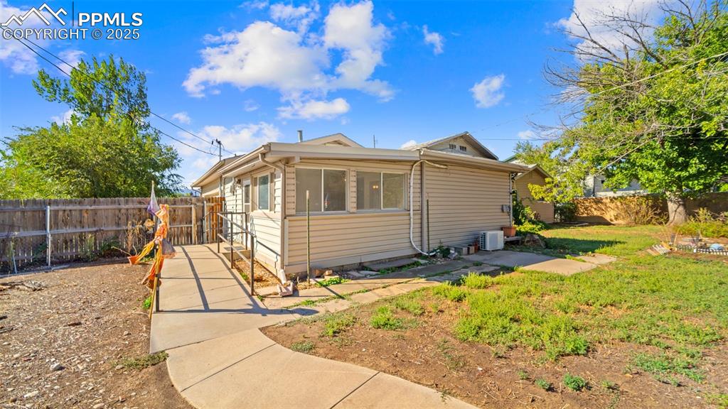 Image 24 of 33: View of side of property featuring a fenced backyard and a sunroom