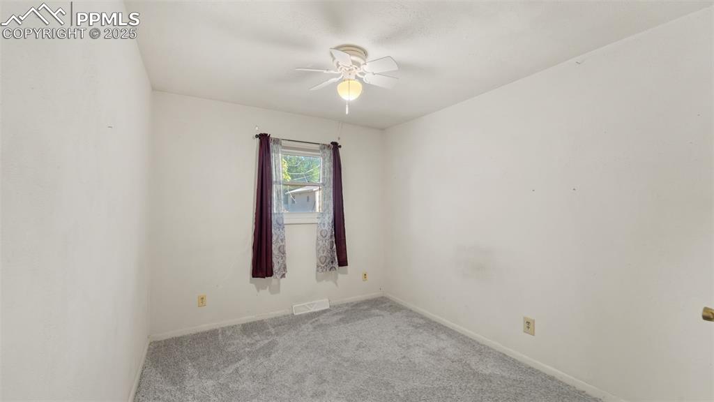 Image 9 of 33: Carpeted empty room with baseboards and a ceiling fan