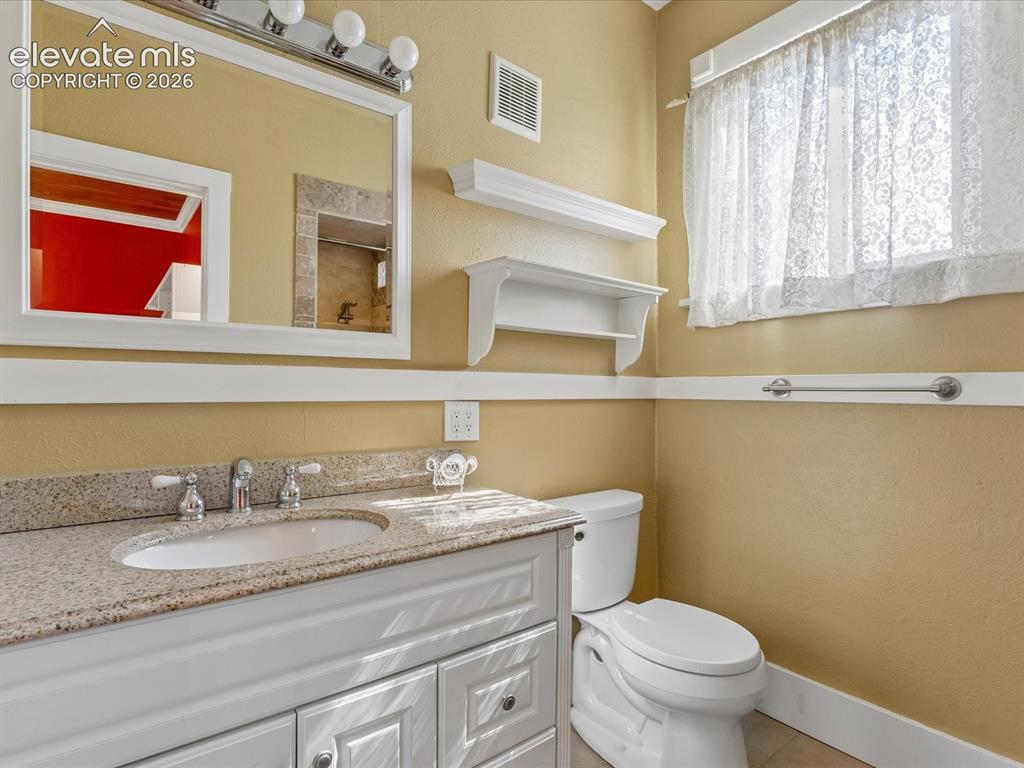 Image 10 of 35: Bathroom vanity featuring a light-colored stone-finish countertop with an u