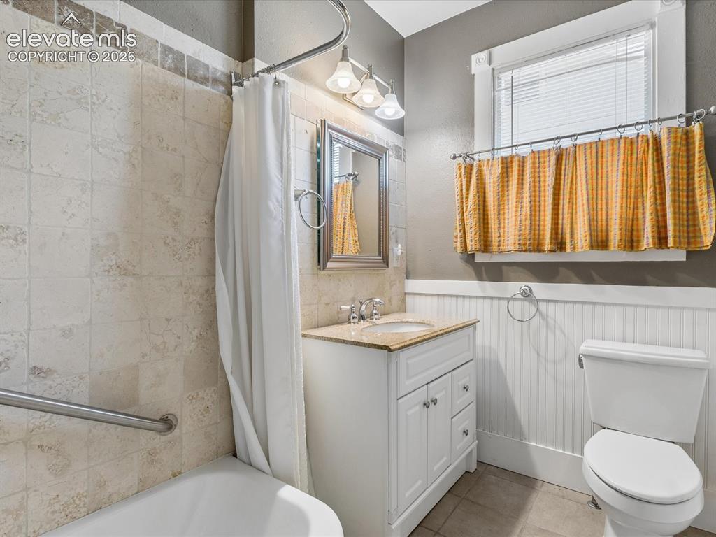 Image 14 of 35: Bathroom featuring a white vanity with a light-toned countertop, a shower/t