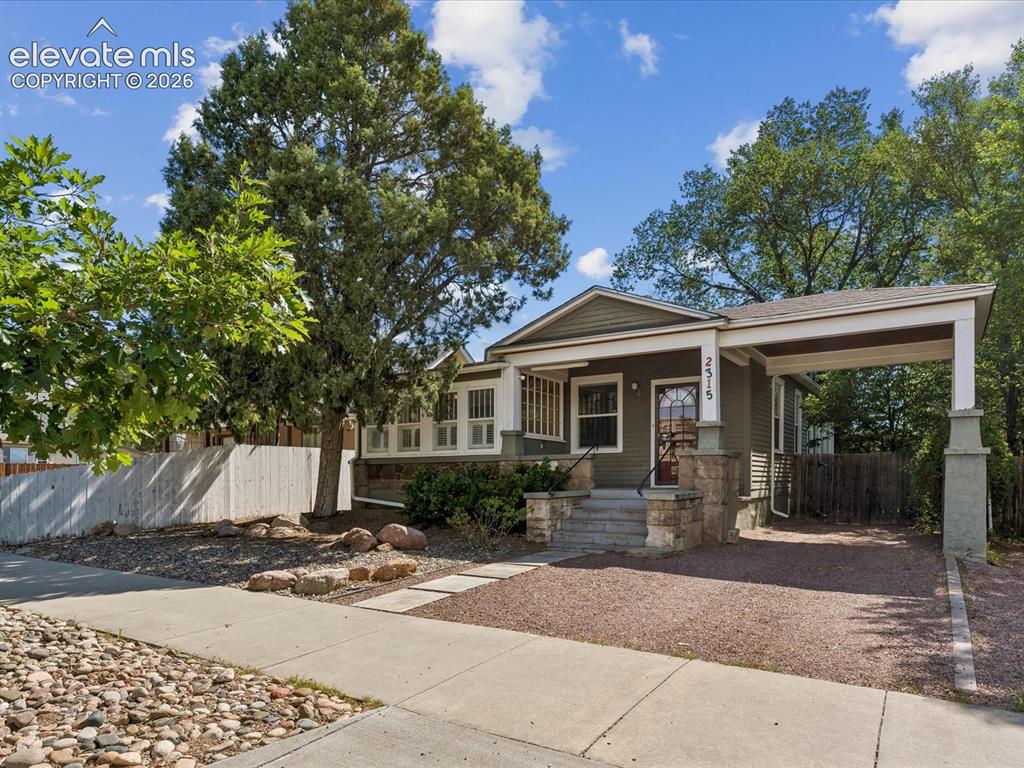 Image 4 of 35: Craftsman-style home featuring a covered entryway, a porte-cochère, stone-c