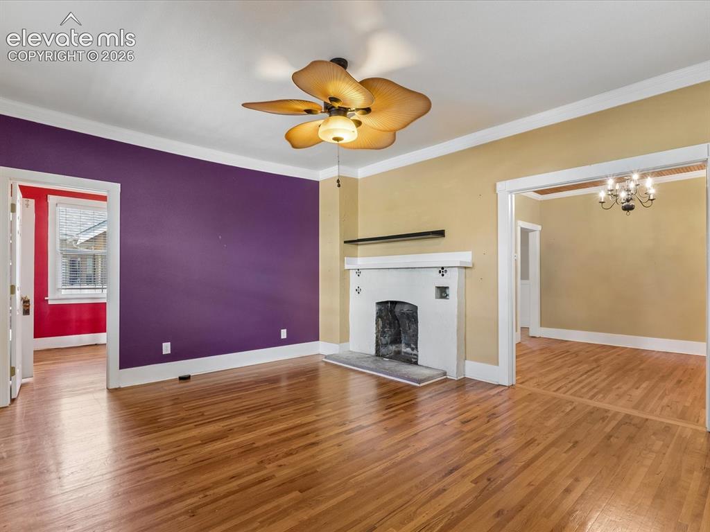 Image 5 of 35: Expansive living space featuring wood-finish flooring, a decorative firepla