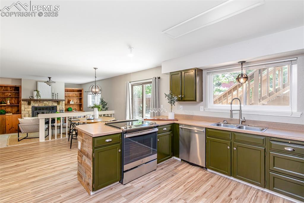 Image 10 of 38: Kitchen with green cabinets, appliances with stainless steel finishes, a pe